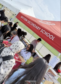 students line up beside red Bayview SS tent