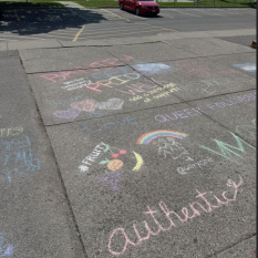rainbow and affirming messages written in chalk on sidewalk