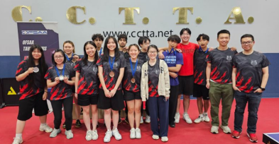 students in sports uniforms hold or wear medals in front of OECTA words on the wall.