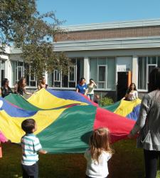 students and children playing with parachute