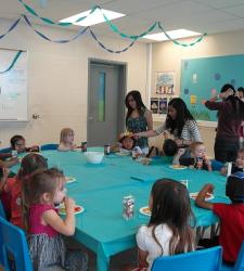 students and children sitting at table